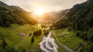 Ein Bild von einer Urner Berglandschaft mit einem idyllischen Fluss im Zentrum.